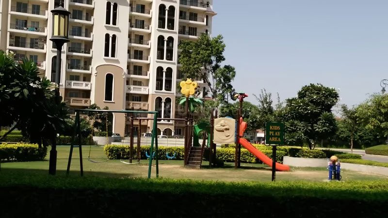 Expansive green spaces and a dedicated kids play area at DLF New Town Heights